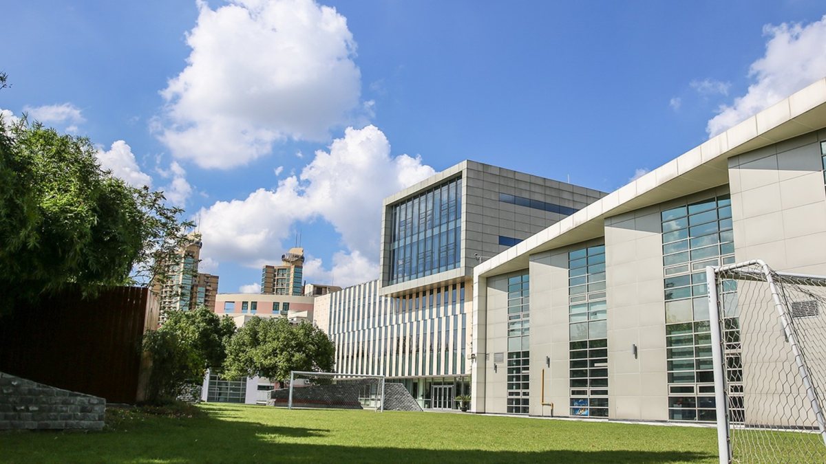 Concordia Shanghai glass-fronted campus building beside a playing field